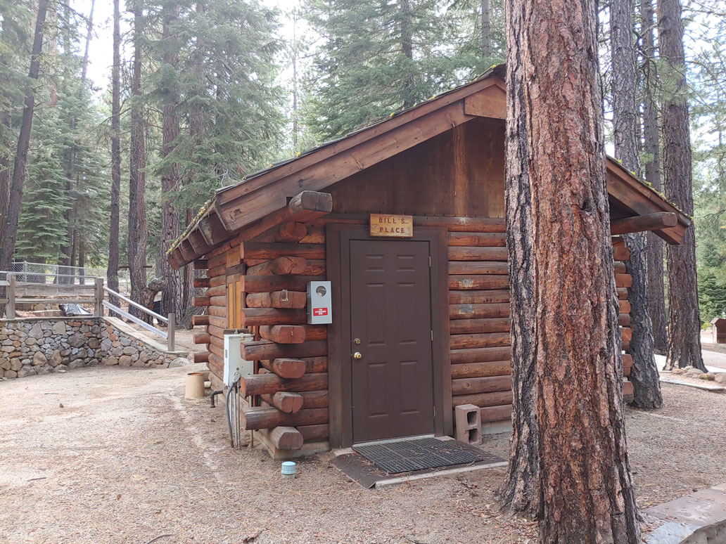 Log cabin with sign on door that says Bill's Place